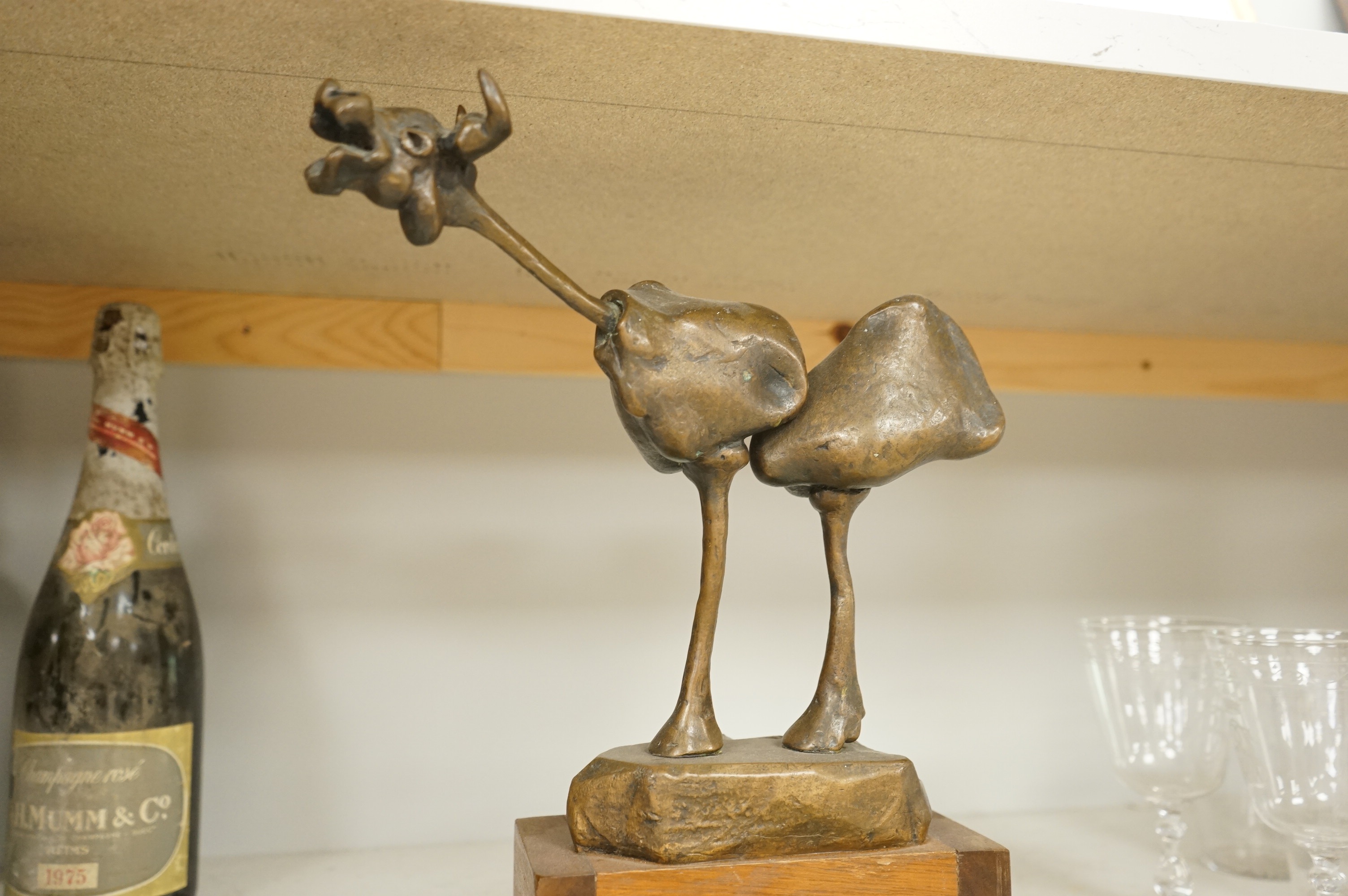 An abstract bronze model of a cow, 34cm and an Art Deco green onyx box, the lid surmounted with a cold painted bronze spaniel, 16.5cm wide.
